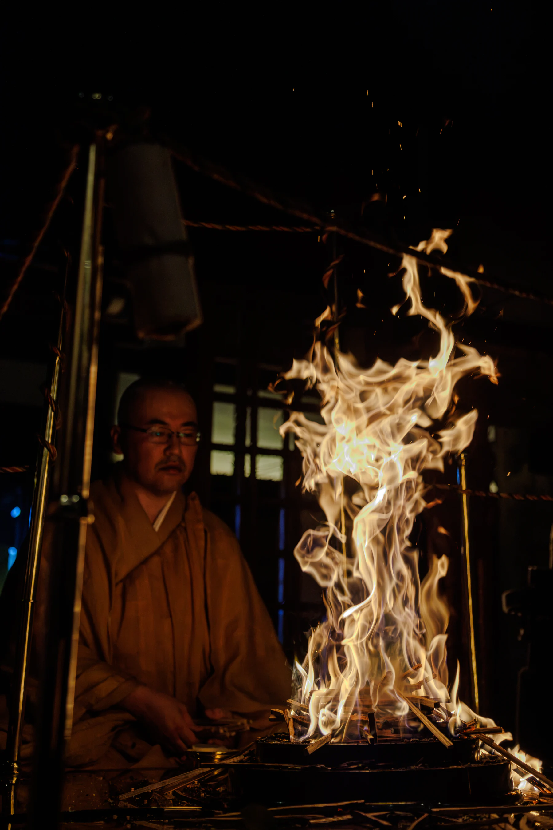 The priest beside the wisdom-fire rising from the goma altar