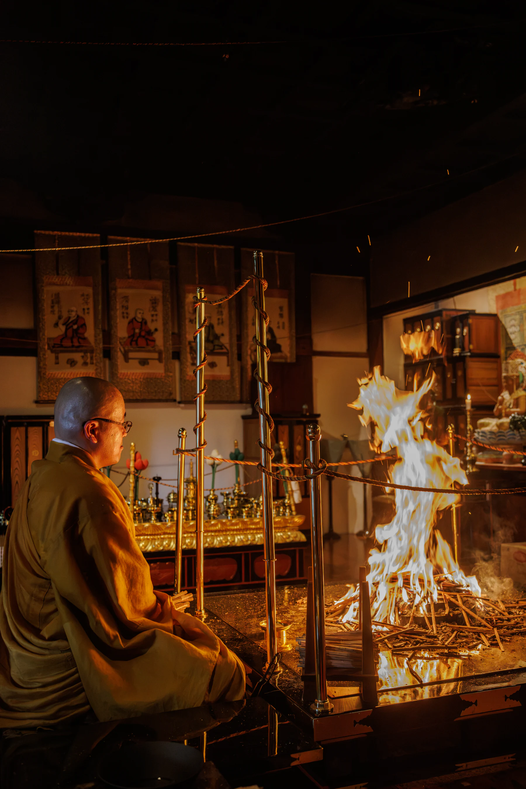 The priest seated before the goma altar inside the hall